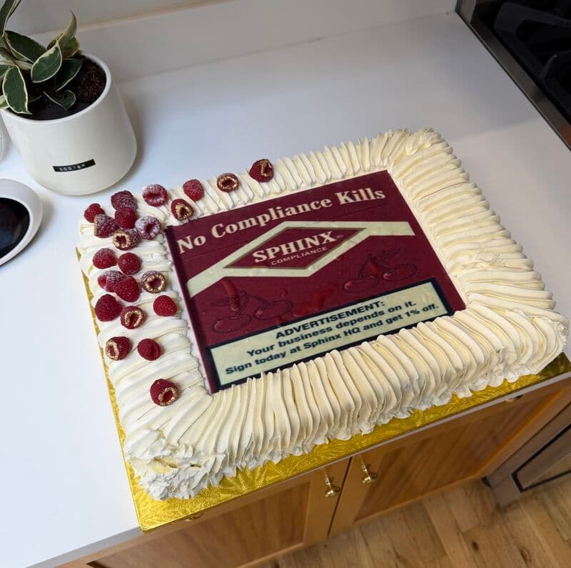 A coldcake delivered to Sphinx's office, decorated with a 'No Compliance Kills' Sphinx Compliance ad